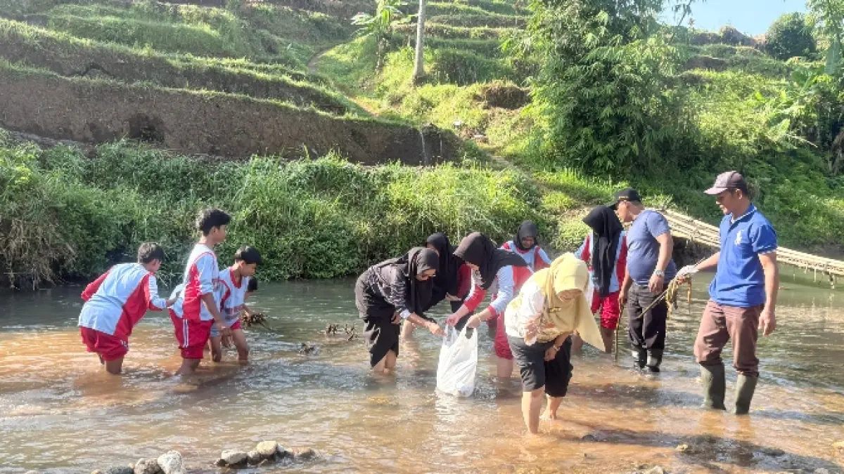 PEDULI: Warga SMPN 2 Dampit melakukan pembersihan sampah plastik dan rumah tangga di sekitar anak Sungai Srimulyo.