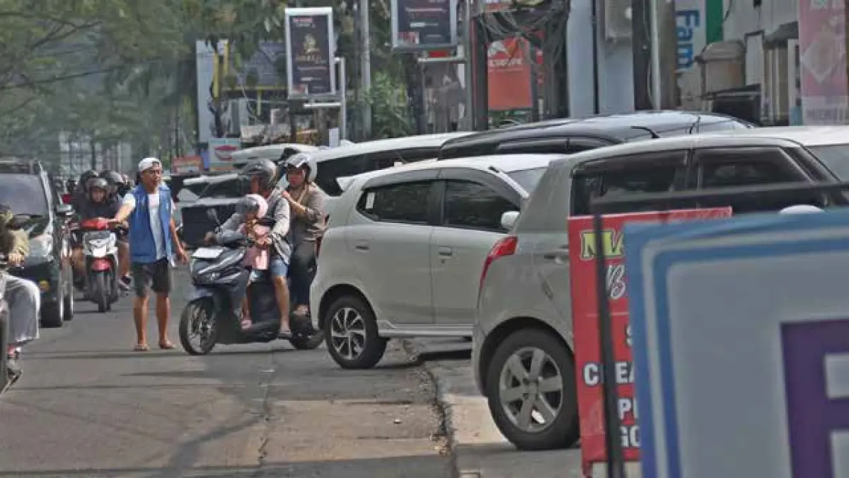 BUTUH DITINGKATKAN: Sejumlah kendaraan roda empat terparkir di tepi Jalan Soekarno-Hatta. Target penerimaan retribusi parkir sebesar Rp 15 miliar pada tahun 2026.