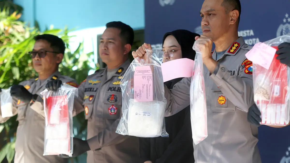 (kanan) menunjukkan barang bukti sabu-sabu yang diamankan dari tiga tersangka. (Darmono/Radar Malang)