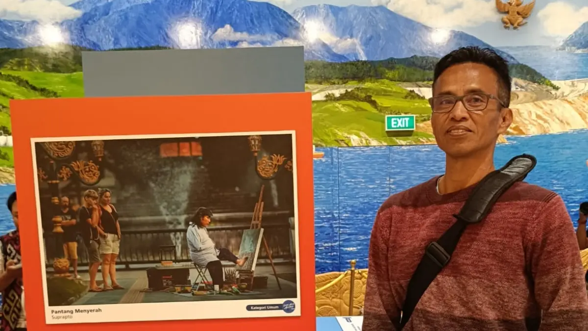 Suprapto berpose dengan karya fotografinya dalam salah satu perlombaan beberapa waktu lalu. (Dokumen Suprapto)