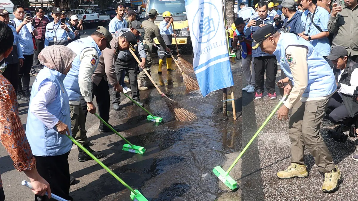 PROGRAM PUSAT: Wali Kota Malang Wahyu Hidayat (kanan) ikut turun melakukan kerja bakti di sekitar Alun-Alun Merdeka, kemarin. (Darmono/Radar Malang)