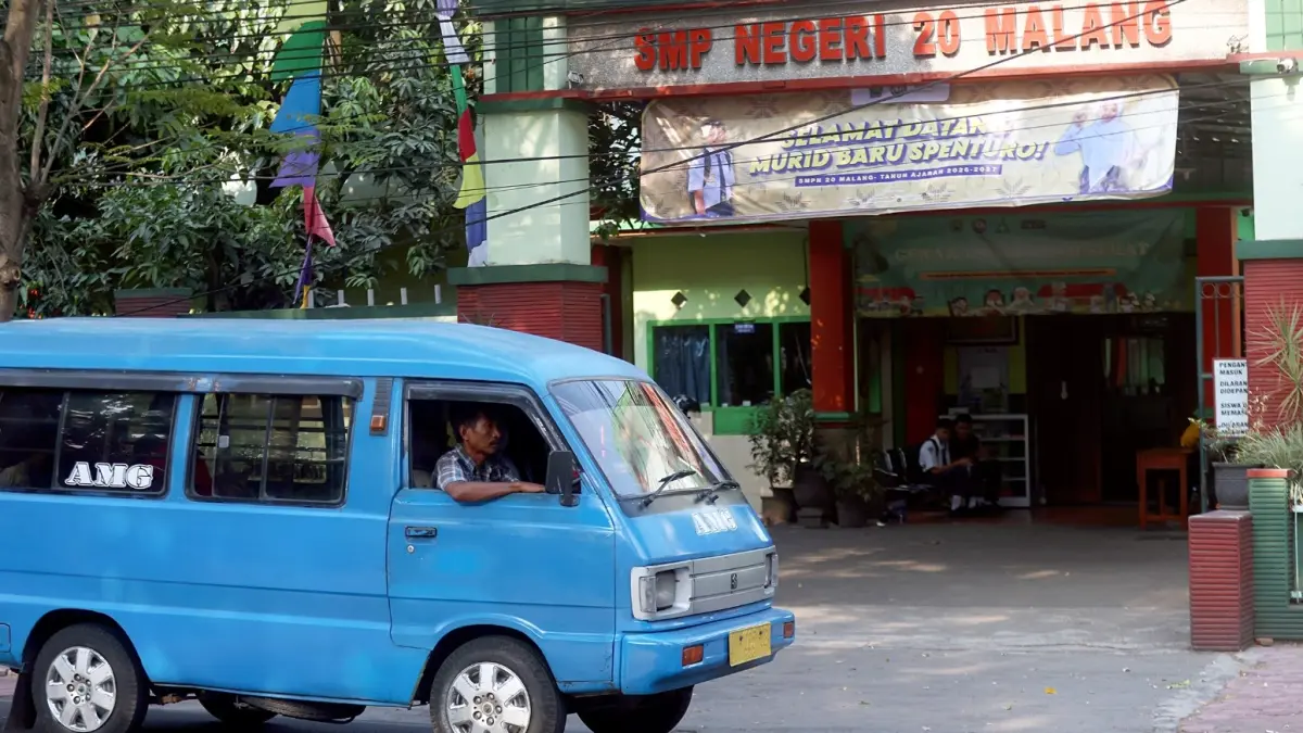 BELUM BEROPERASI: Salah satu angkot melintas di depan SMP Negeri 20 Malang, kemarin siang (13/7). (Darmono/Radar Malang)