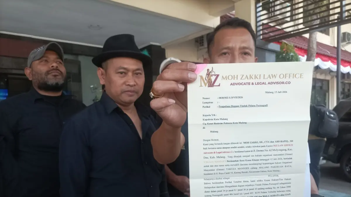 Kuasa hukum Yakuza Manages Moh Zakky memperlihatkan surat laporan yang telah disampaikan ke Polresta Malang Kota, Senin (13/7). (Nabila Amelia/Radar Malang)