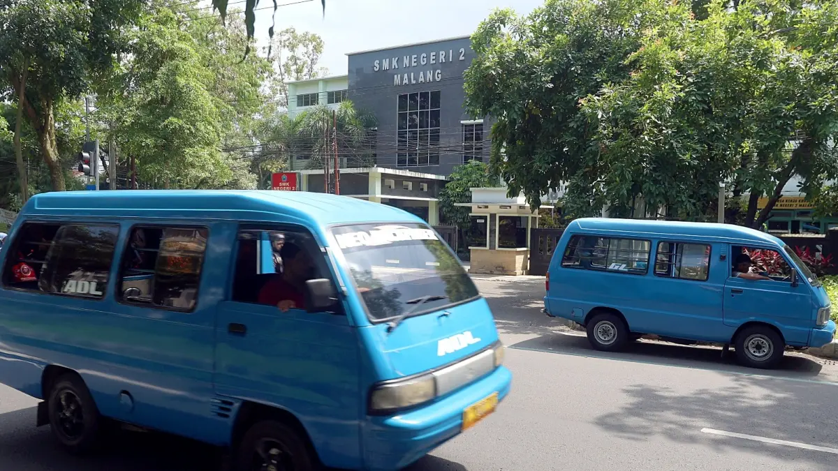 BAKAL DILENGKAPI STIKER: Dua angkot melintas di Jalan Veteran, kemarin (14/7). Ada 80 armada yang bakal beroperasi di program angkot pelajar. (Darmono/Radar Malang)