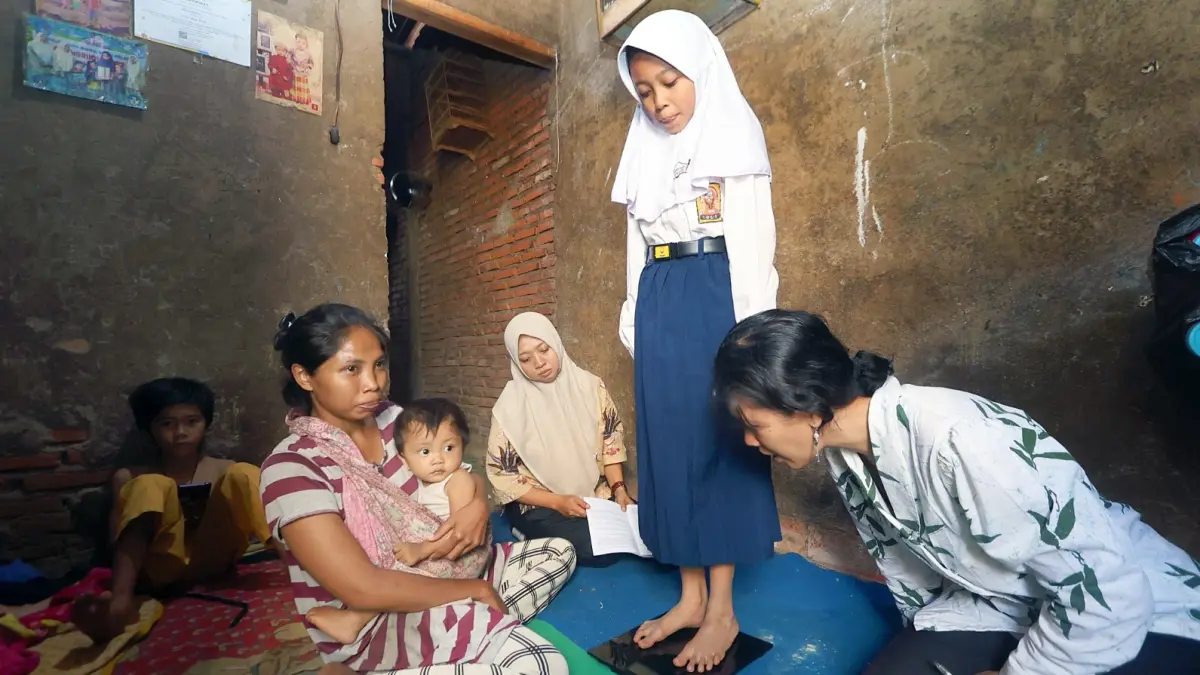 RINDU SEKOLAH: Ananda Dian Ayu Sekar Arum, pelajar yang berdomisili di Jalan KH Malik Dalam, Kelurahan Buring, Kedungkandang mendapat home visit dari guru Sekolah Rakyat Menengah Pertama (SRMP) 16, kemarin. (Darmono/Radar Malang)