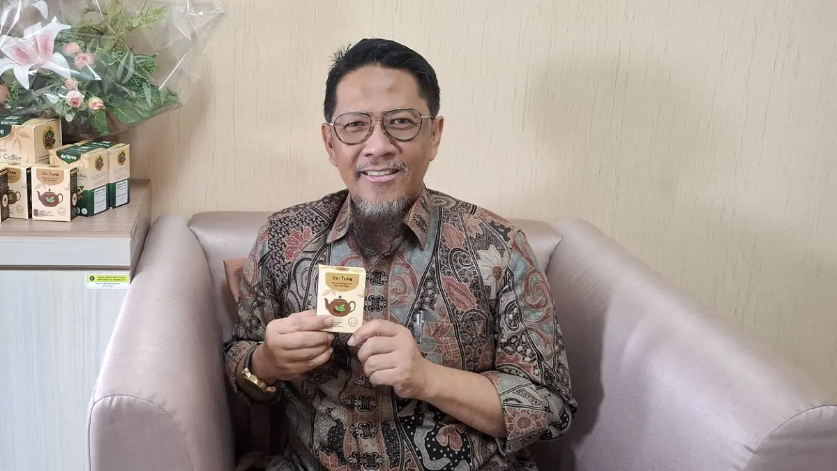 Prof Mohammad Saifur Rohman memperlihatkan de-Teko, produk hasil riset hampir satu dekade yang memadukan ekstrak kopi hijau dan teh hijau sebagai pendamping terapi medis kemarin. (Ramizard Rafsanjani/Radar Malang)