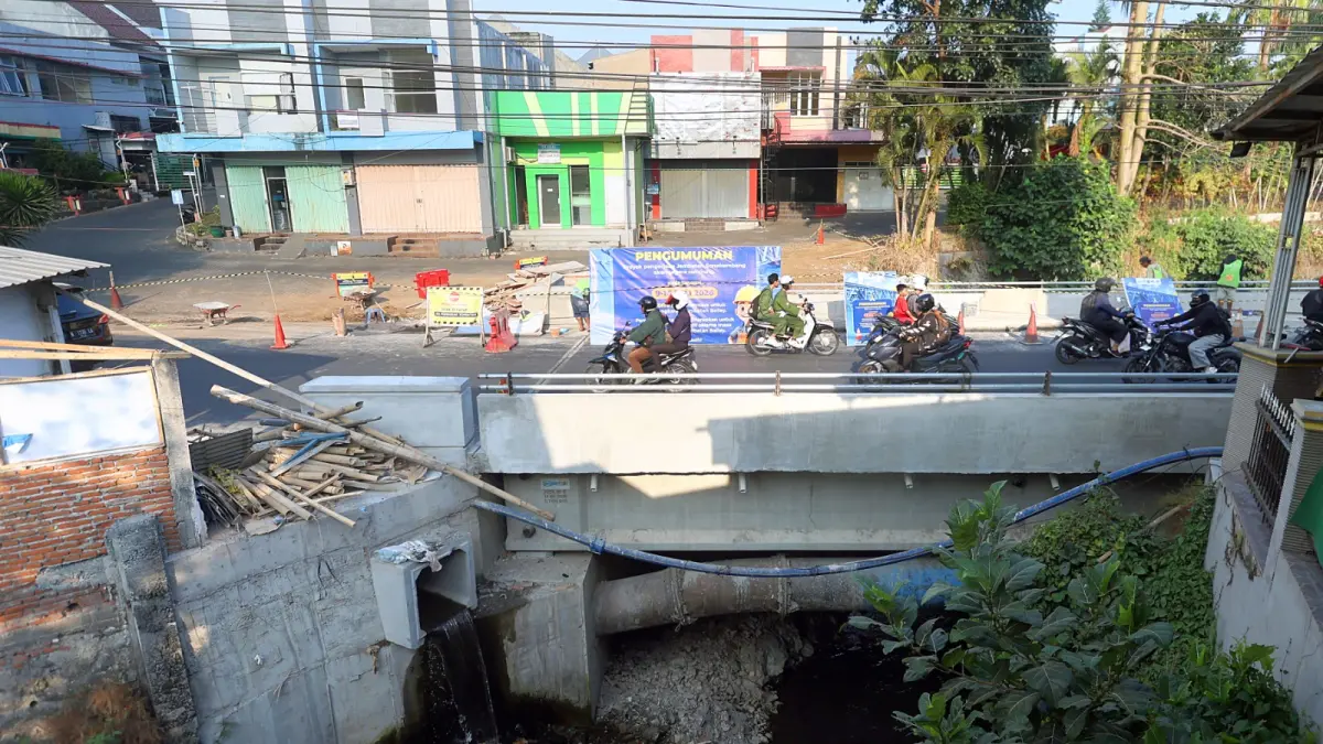 Foto kanan, pembangunan ulang jembatan mulai memasuki tahap akhir, kemarin (17/7). (Darmono/Radar Malang)