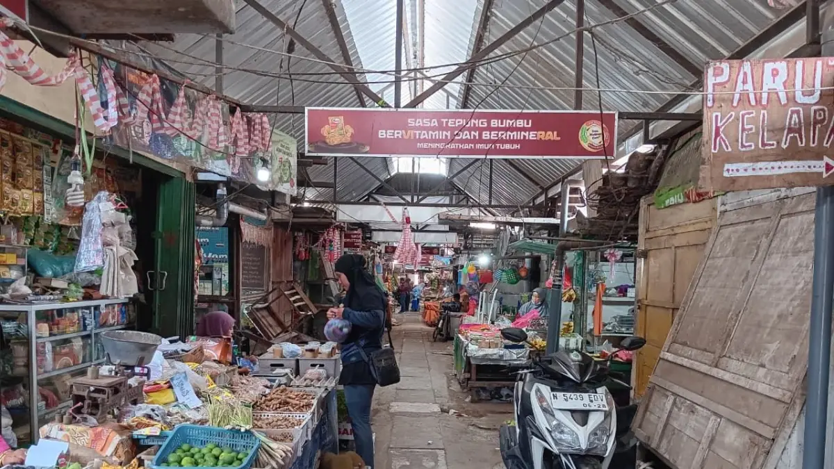 KUALITAS SDM: Seorang pedagang di Pasar Pakisaji melayani konsumen. Mereka harus beradaptasi dengan teknologi agar tidak tergilas pasar online.