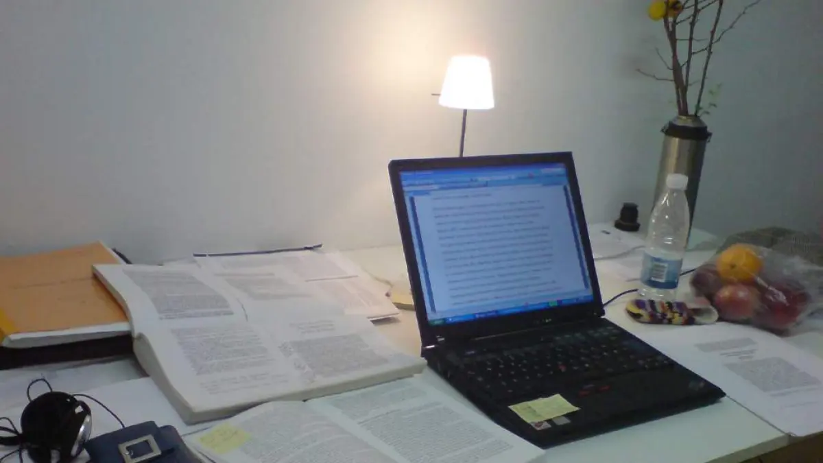 Laptop dan tumpukan jurnal serta buku diatas meja untuk mengerjakan skripsi (Sumber: ZonaMahasiswa)