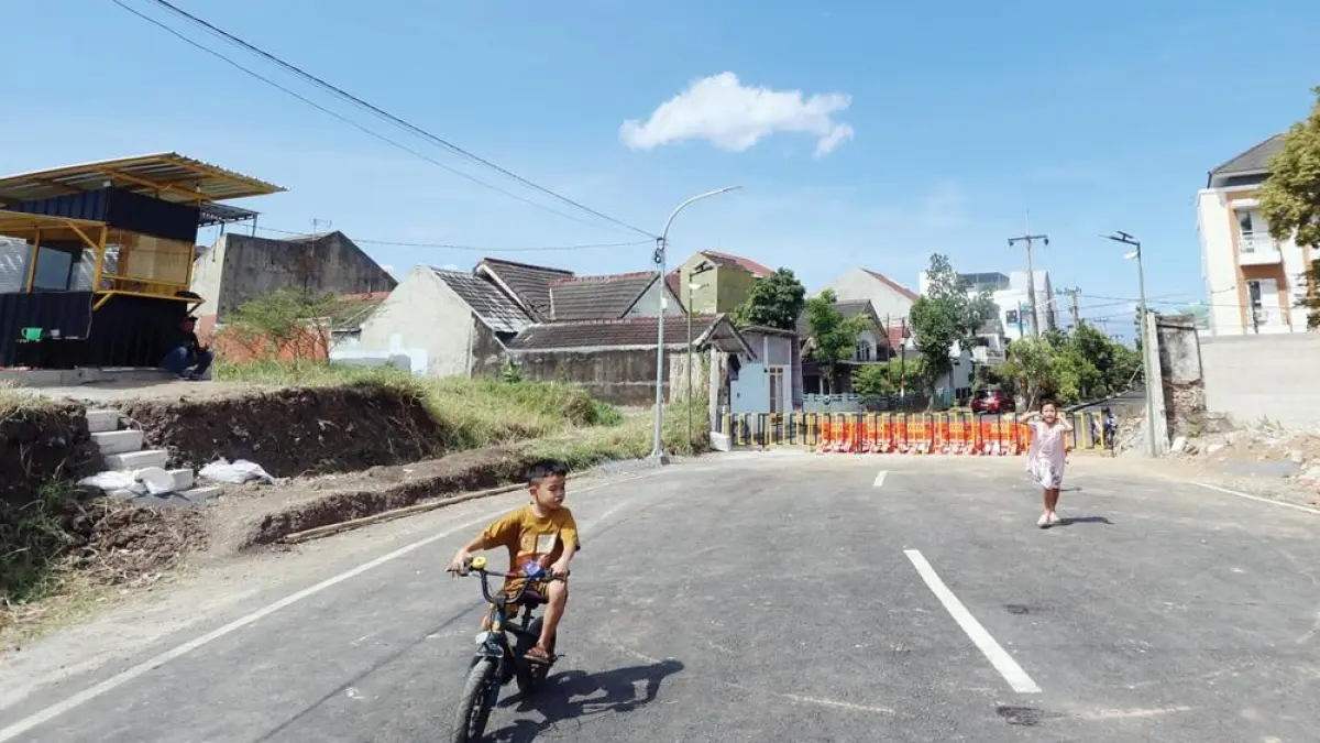 TETAP MENOLAK: Warga menutup akses jalan tembus Griyashanta dengan barrier khusus. Mereka juga menerapkan sistem buka tutup di gerbang utama. (Darmono/Radar Malang)