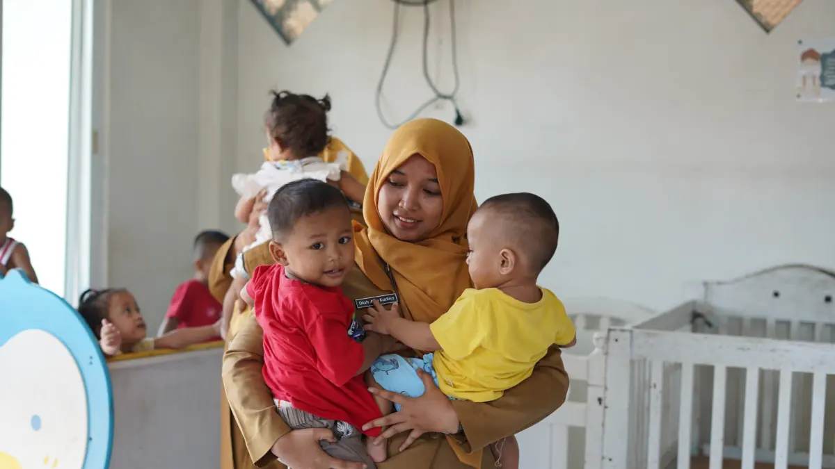 PEDULI: Guru SMK Negeri 1 Kota Malang menggendong bayi yang diasuh di LKSA Peduli Kasih KNDJH.