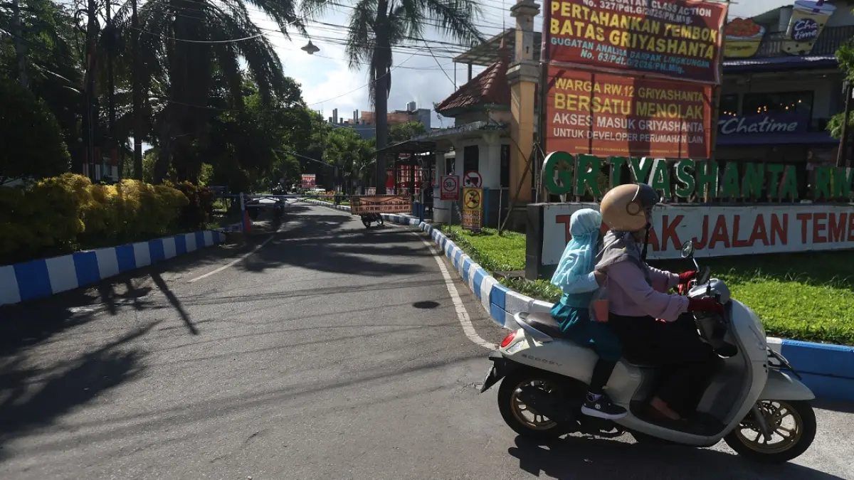 TETAP DIUJI COBA: Gerbang utama Perumahan Griyashanta masih diberlakukan sistem buka tutup oleh warga sekitar, kemarin. (Darmono/Radar Malang)