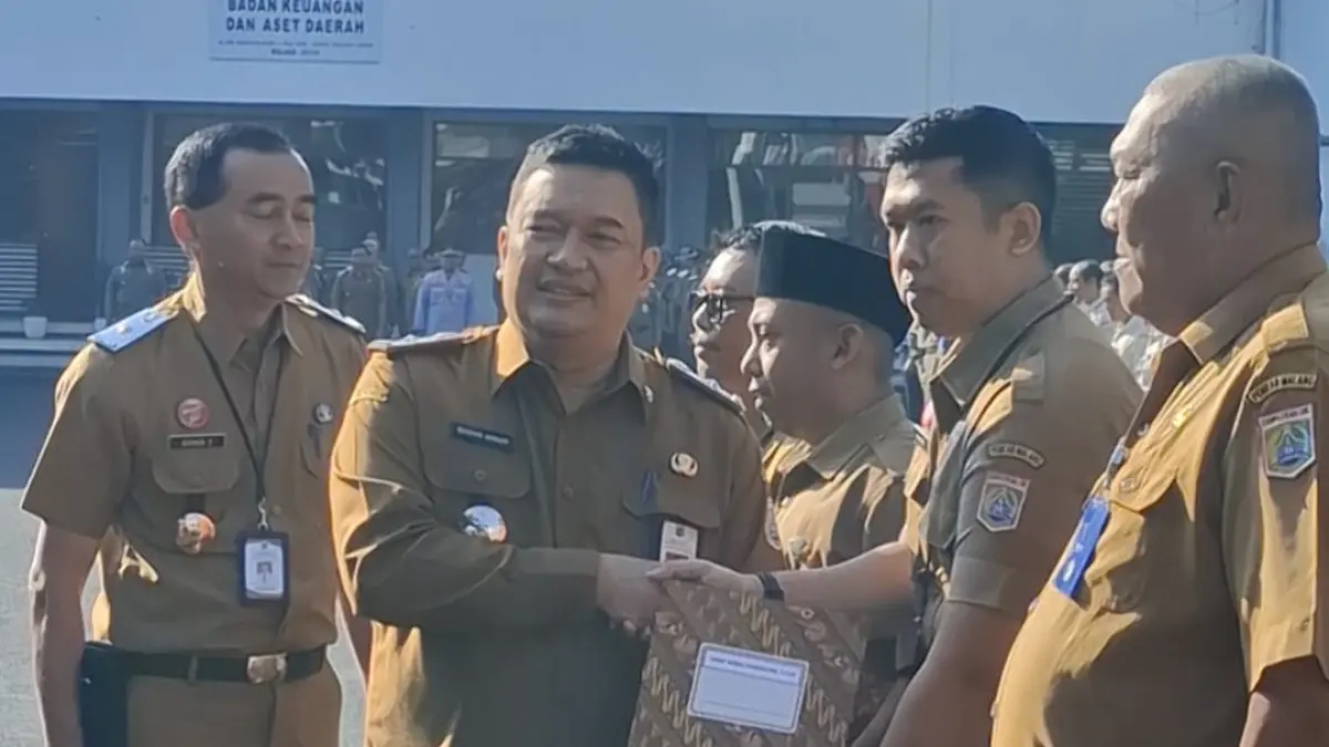 Sekretaris Daerah (Sekda) Kabupaten Malang M. Budiar Anwar (kiri) menyerahkan SK pensiun kepada ASN, Senin (27/7). (Prokopim Kabupaten Malang)
