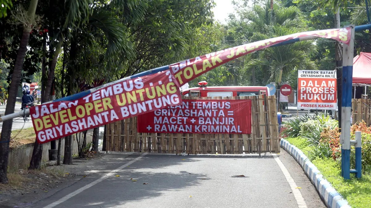 TEMPEL BANYAK BANNER: Warga memblokade akses ke Perumahan Griyashanta menggunakan pagar dari bambu. (Darmono/Radar Malang)