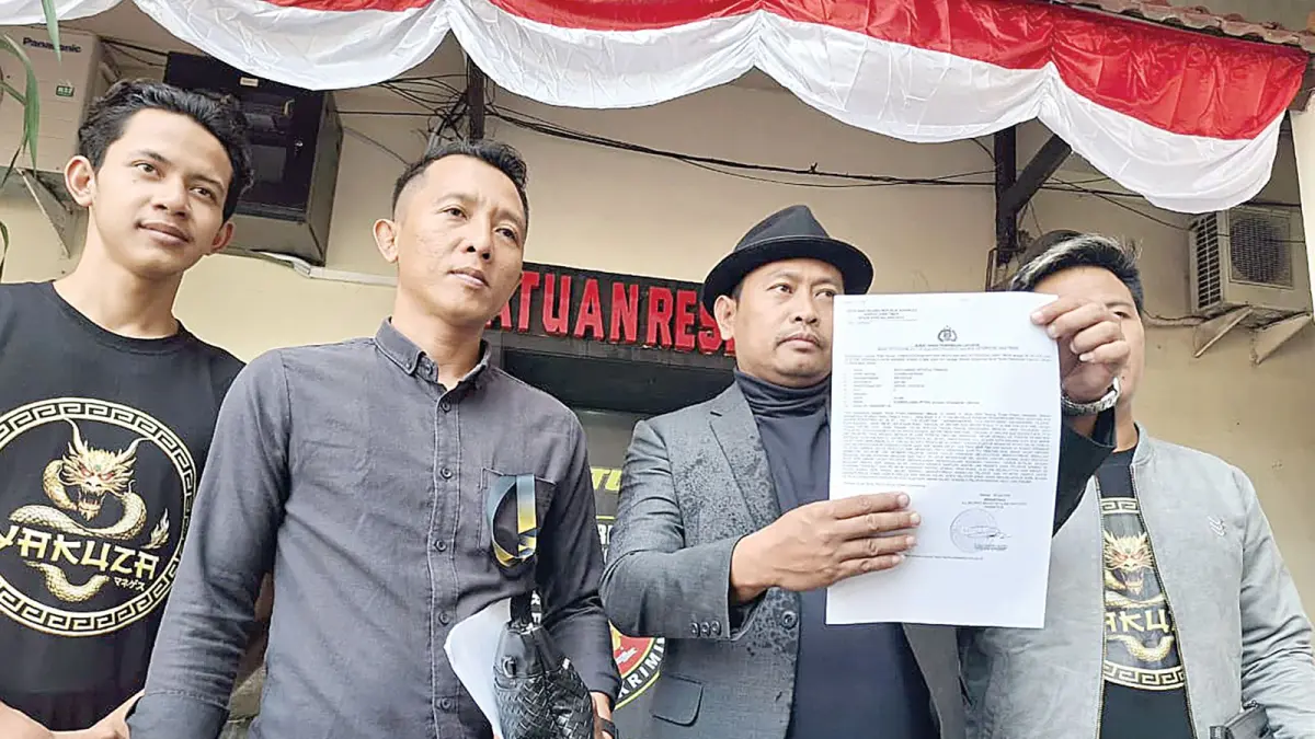 SEKALIAN SERAHKAN TERSANGKA: Kuasa hukum Yakuza Maneges Muhammad Zakki menunjukkan bukti laporan ke Polresta Malang Kota, kemarin (28/7). (Nabila Amelia/Radar Malang)