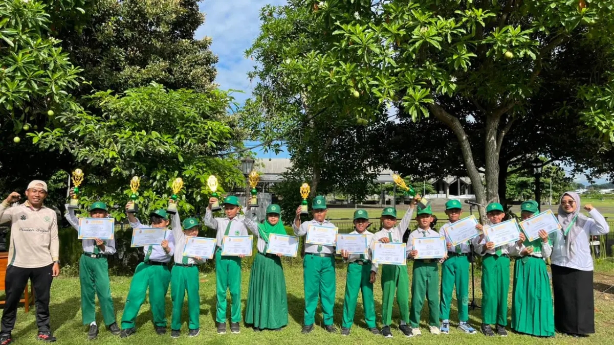 Siswa-siswi MI Raden Bagus menunjukkan piala dan piagam penghargaan