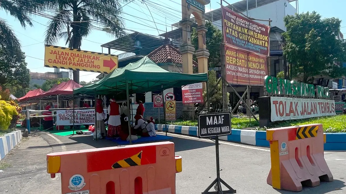 BERSIKUKUH MENOLAK: Warga RW 12 Perumahan Griyashanta masih menutup akses di gerbang utama, kemarin. (Andika Satria Perdana/Radar Malang)