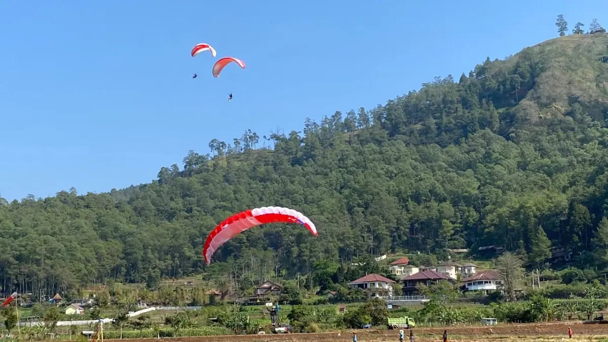 Atlet paralayang melakukan landing di Lapangan Songgokerto. (Rori Dinanda Bestari/Radar Malang)
