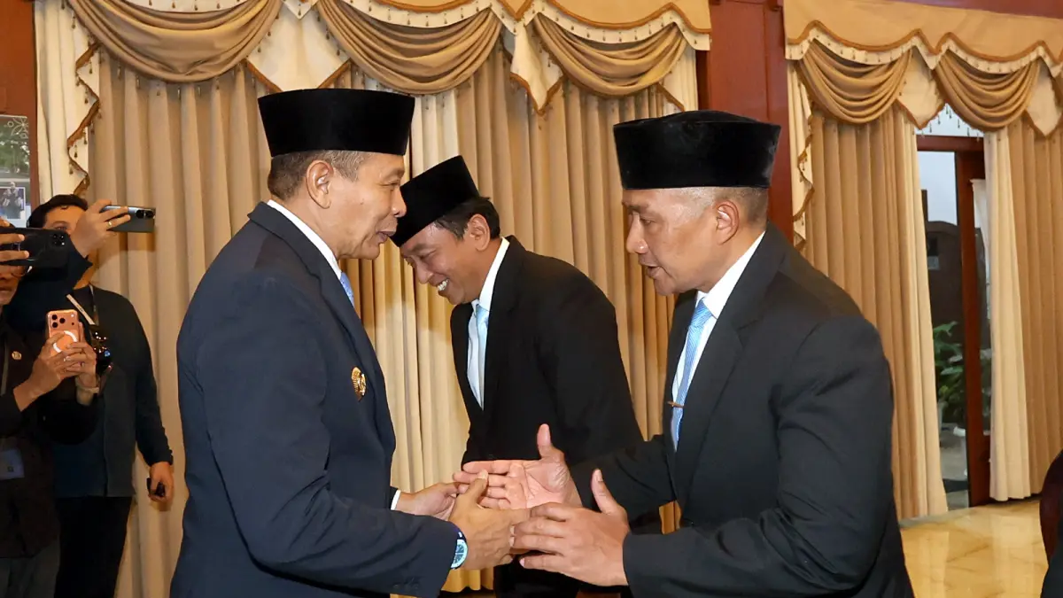 PAKAI SISTEM BARU: Wali Kota Malang Wahyu Hidayat (kiri) menyalami Erik Setyo Santoso yang dirotasi dari posisi Sekda ke Asisten Administrasi Umum Setda Kota Malang, kemarin. (Darmono/Radar Malang)