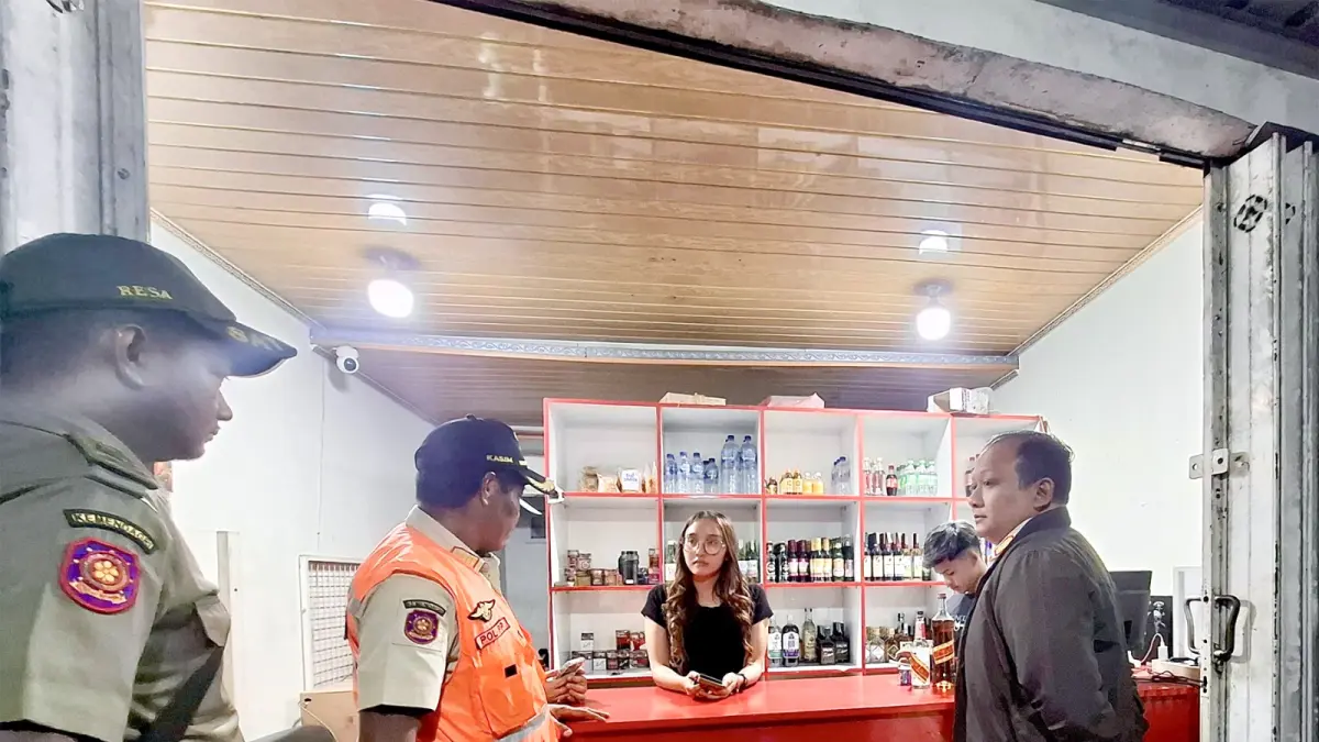CEK  LEGALITAS: Beberapa personel Satpol PP Kabupaten Malang berkomunikasi dengan kasir warung di Jalan Raya Bugis, Desa Saptorenggo, Kecamatan Pakis beberapa waktu lalu.