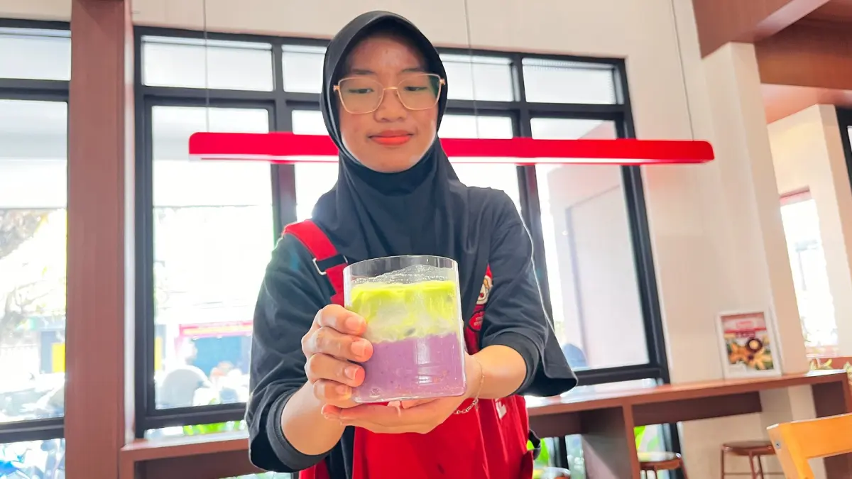 SIAP DIMINUM: Pramusaji Tendo Gyoza menyajikan ube matcha kepada pengunjung kemarin siang.