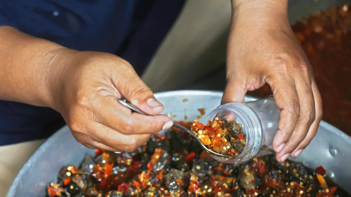 BISA TINGKATKAN PENJUALAN: Pekerja di UMKM Sambal Mama Ni tengah mengemas produk. Pemkot Malang mengimbau pengusaha segera mendaftar self declare. (Foto: Darmono/Radar Malang)