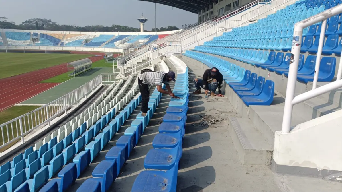 Pekerja memperbaiki lantai tribun Stadion Kanjuruhan yang retak