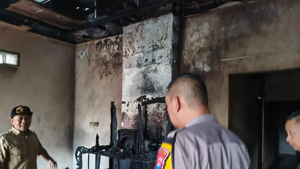 Perangkat desa dan polisi memeriksa rumah warga setelah kebakaran