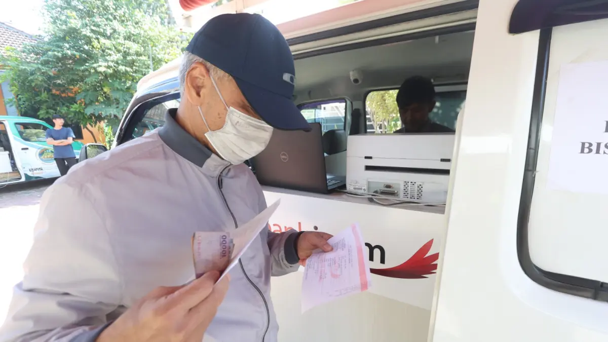 PERLU DITINGKATKAN: Seorang warga Kota Malang menuntaskan pembayaran pajak bumi bangunan di acara Sambang Kelurahan di Mojolangu bulan Juni lalu. (Darmono)