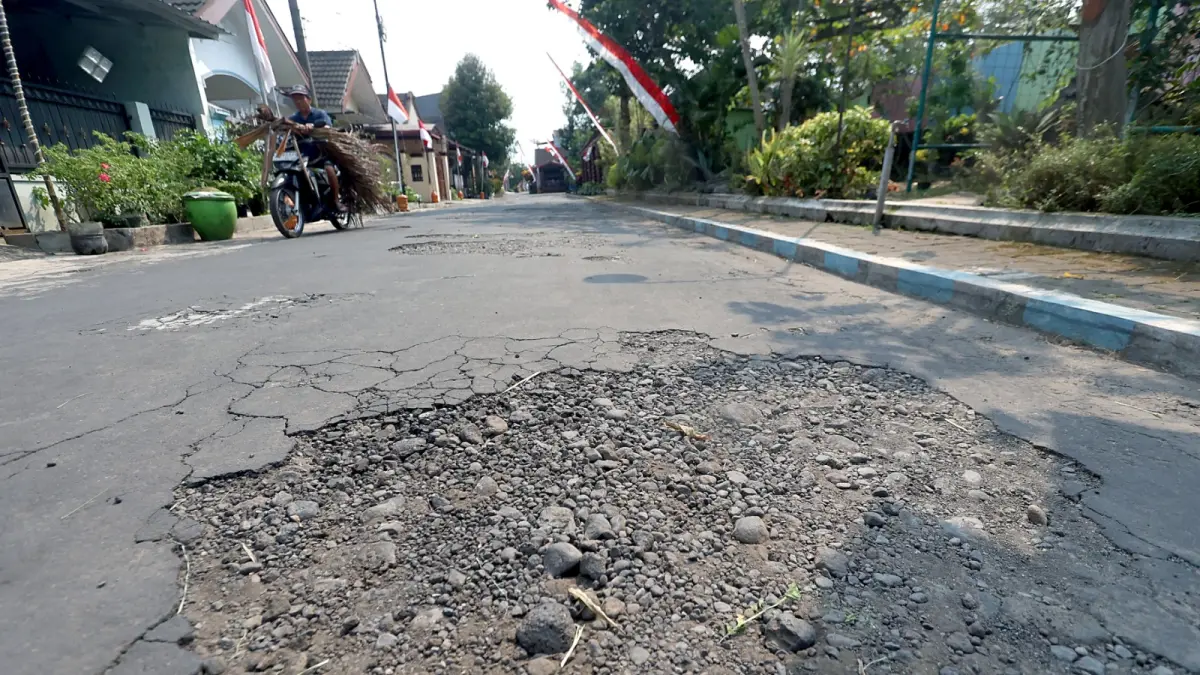 ADA TEROBOSAN BARU: Kondisi jalan di Perumahan Puri Cempaka Putih I masih kurang layak. (Darmono/Radar Malang)