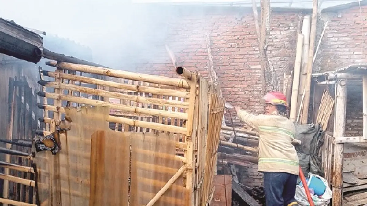 Petugas Damkar Kabupaten Malang berupaya memadamkan sisa api di rumah warga Dusun Krajan, Desa Ngroto, Kecamatan Pujon, kemarin (6/8). (Damkar Kabupaten Malang for Radar Kanjuruhan)