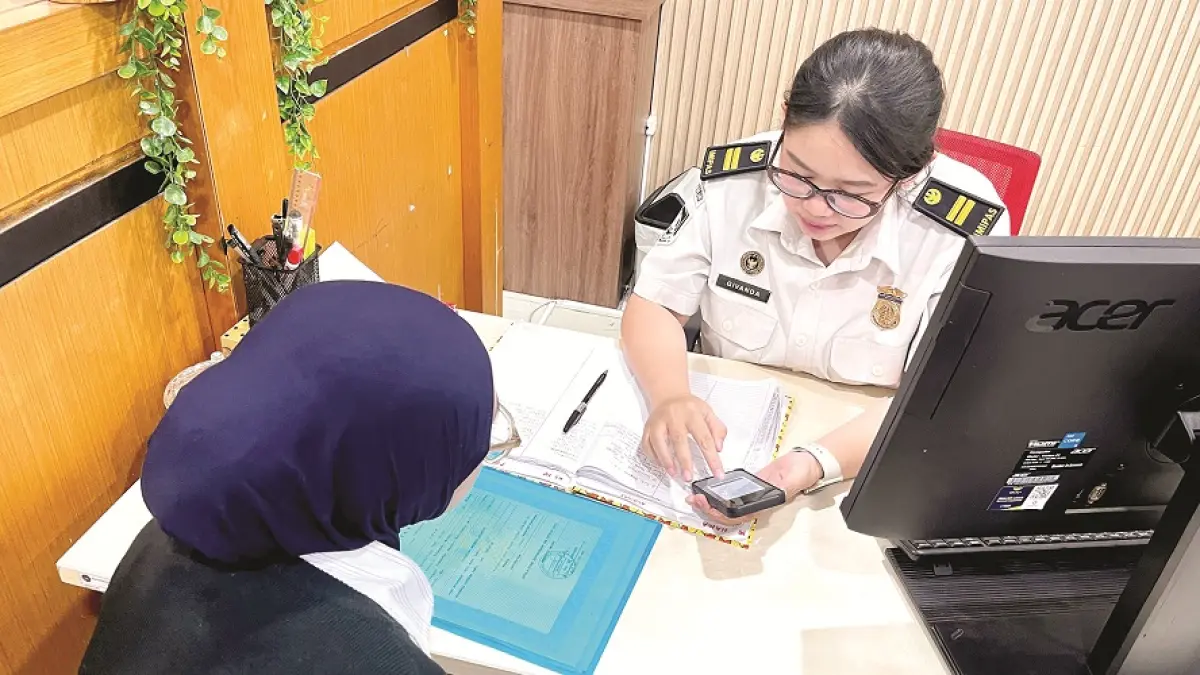 Petugas Kantor Imigrasi Kelas I TPI Malang melayani warga Kabupaten Malang yang hendak mengajukan paspor. (Nahdiatul Affandiah/Radar Malang)
