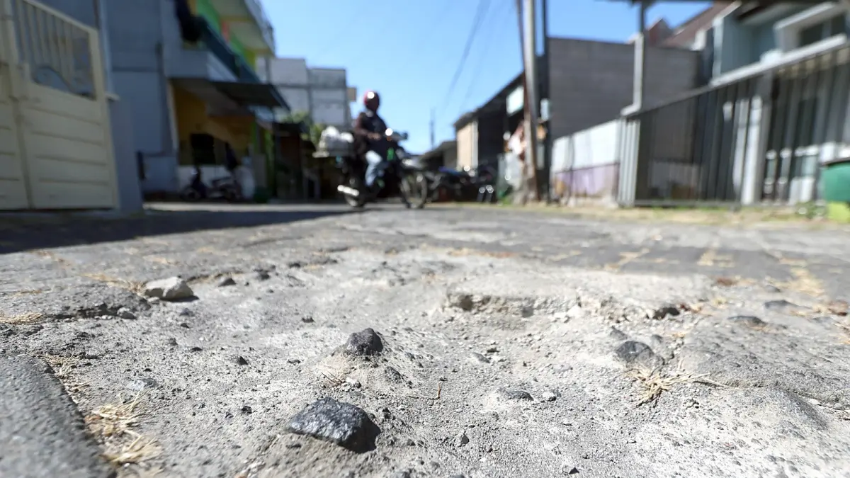 FASUM: Ruas jalan di salah satu perumahan di Kota Malang rusak. Pemkot Malang tidak bisa memperbaiki jika PSU masih belum diserahkan ke pemerintah (Darmono/Radar Malang).