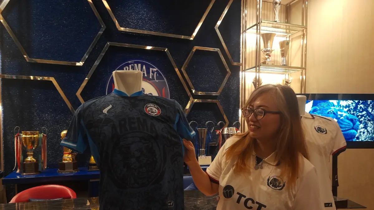 BANYAK PEMINAT: CBO Arema FC Irma Prianti menunjukkan jersey home tim di Kandang Singa, 25 Juli lalu.