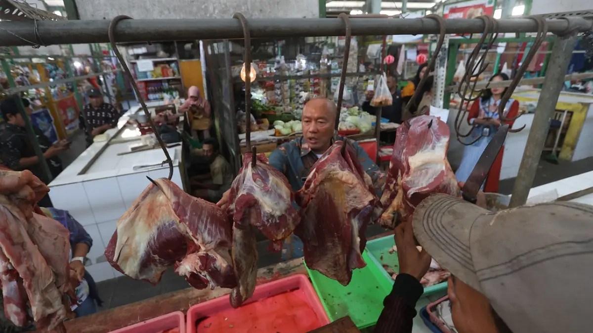NAIK SEJAK DUA PEKAN: Kepala Diskopindag Kota Malang Eko Sri Yuliadi mengecek langsung harga daging sapi di Pasar Bunulrejo, kemarin. (Darmono/Radar Malang)