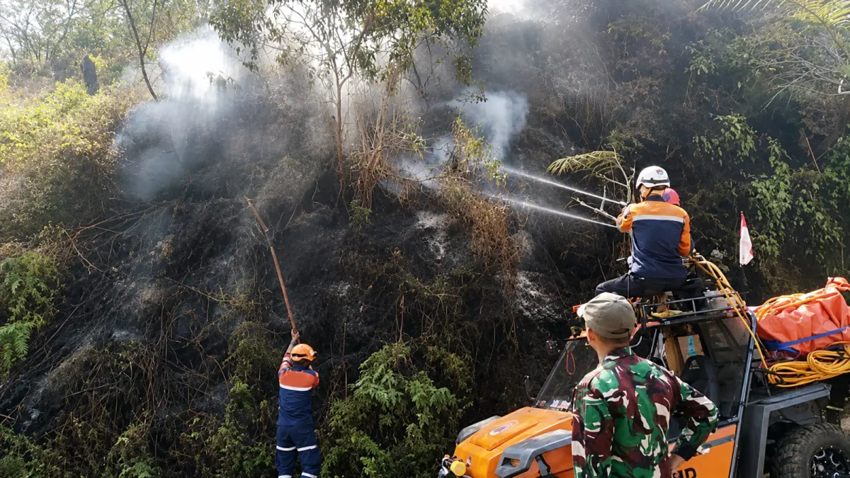 TERUS DIPANTAU: Proses pendinginan dilakukan Satgas TNBTS di sejumlah titik kemarin (15/8). Foto kanan, salah satu anggota TNI dan personel gabungan turun bersama-sama. (Satgas TNBTS For Radar Malang)&nbsp;