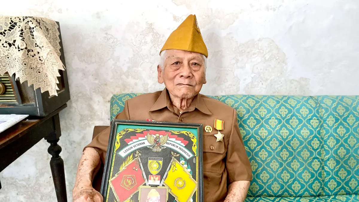 Supakim Hardijanto membawa simbol dari LVRI di kediamannya di Desa Junrejo, Kecamatan Junrejo pada Sabtu (15/8). (Rori Dinanda Bestari/Radar Malang)