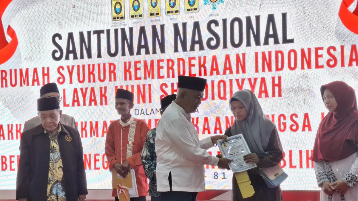Bupati Malang H M. Sanusi menyerahkan bantuan kepada penerima program bedah rumah kemarin siang (23/8). (Biyan Mudzaky Hanindito/Radar Malang)