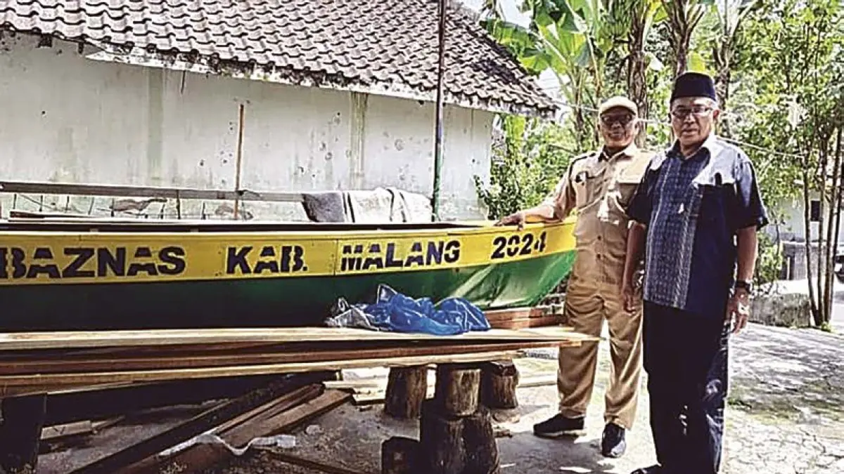 UNTUK MASYARAKAT: Warga berpose di depan kapal nelayan hasil bantuan dari Baznas Kabupaten Malang.