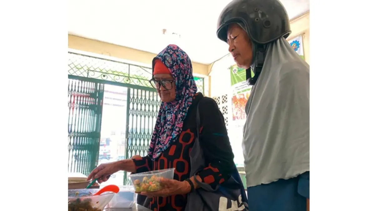 UNTUK SEMUA KALANGAN: Dua lansia mengambil makanan di Griyo Dahar Sarikat Buruh Muslimin Indonesia (Sarbumusi) Kota Batu untuk dibawa pulang.