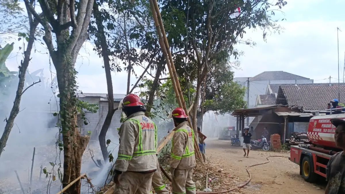 Personel memadamkan api yang menghanguskan lahan