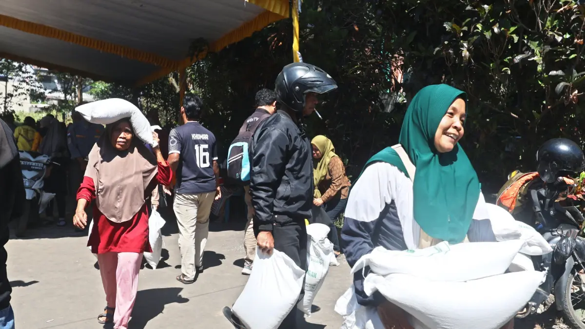MULAI DISALURKAN: Sejumlah warga Kelurahan Polowijen, Kecamatan Blimbing, menerima bantuan beras dari Bulog Cabang Malang, kemarin. (Darmono)