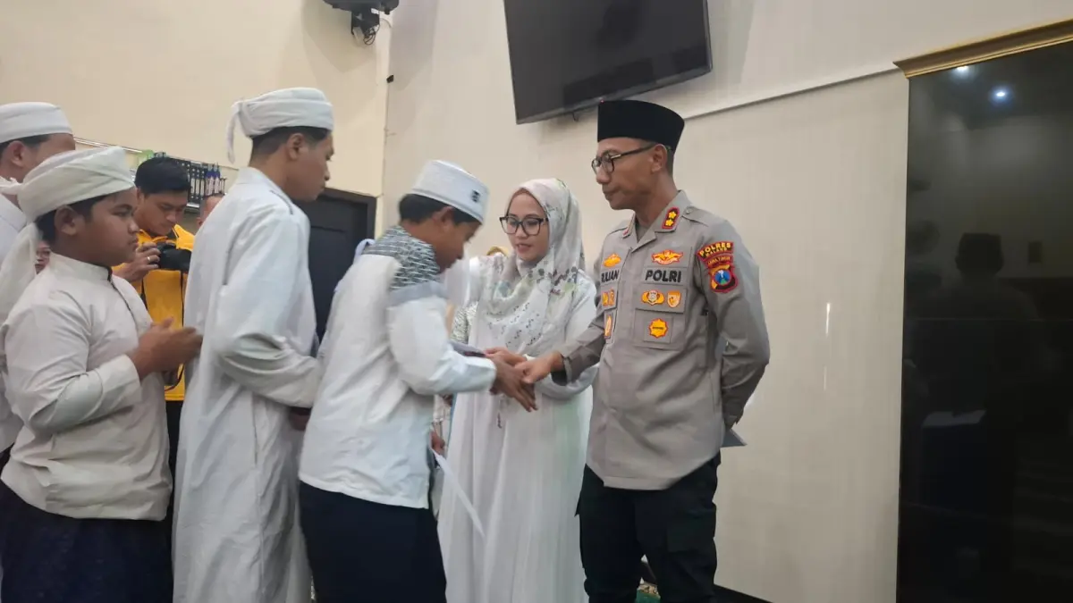 BERSINERGI: Kapolres Malang AKBP Rulian Syauri memberikan santunan anak yatim di Polres Malang, kemarin (28/8)