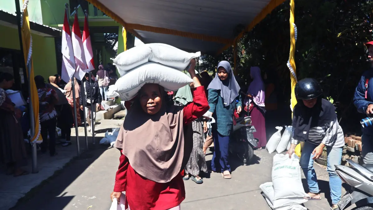 RASAKAN MANFAAT: Salah satu Warga Polowijen, Kecamatan Blimbing menerima bantuan beras 30 kilogram, pada Rabu lalu (26/8).