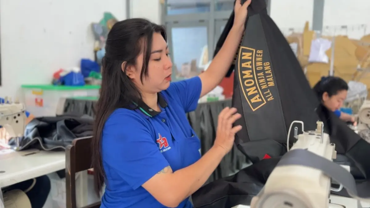 CEK HASIL JAHIT: Koordinator menjahit memeriksa kualitas jaket motor yang dikerjakan warga binaan sebelum proses penyelesaian. (HUMAS LPP FOR RADAR MALANG)