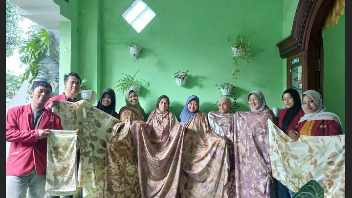 KOMPAK: Tim pengabdian, mahasiswa KKN Mitra Dosen, dan mitra UMKM menunjukkan hasil kain ecoprint dalam kegiatan pemberdayaan di Desa Sumbersekar, Malang.