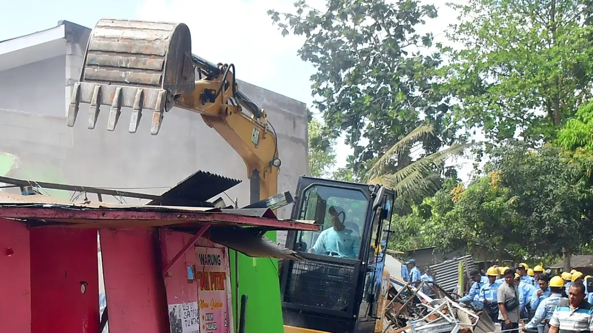 SUDAH DIBERI SP3: Pemkot Malang menurunkan satu alat berat untuk mempercepat proses pembongkaran bangunan semi-permanen di RTH Buring, kemarin. (Darmono/Radar Malang)
