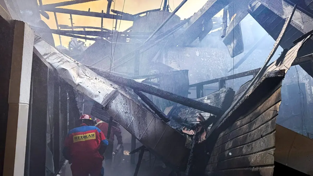BUTUH 1,5 JAM: Salah satu petugas Damkar Kota Malang melakukan proses pendinginan. (Damkar Kota Malang For Radar Malang)