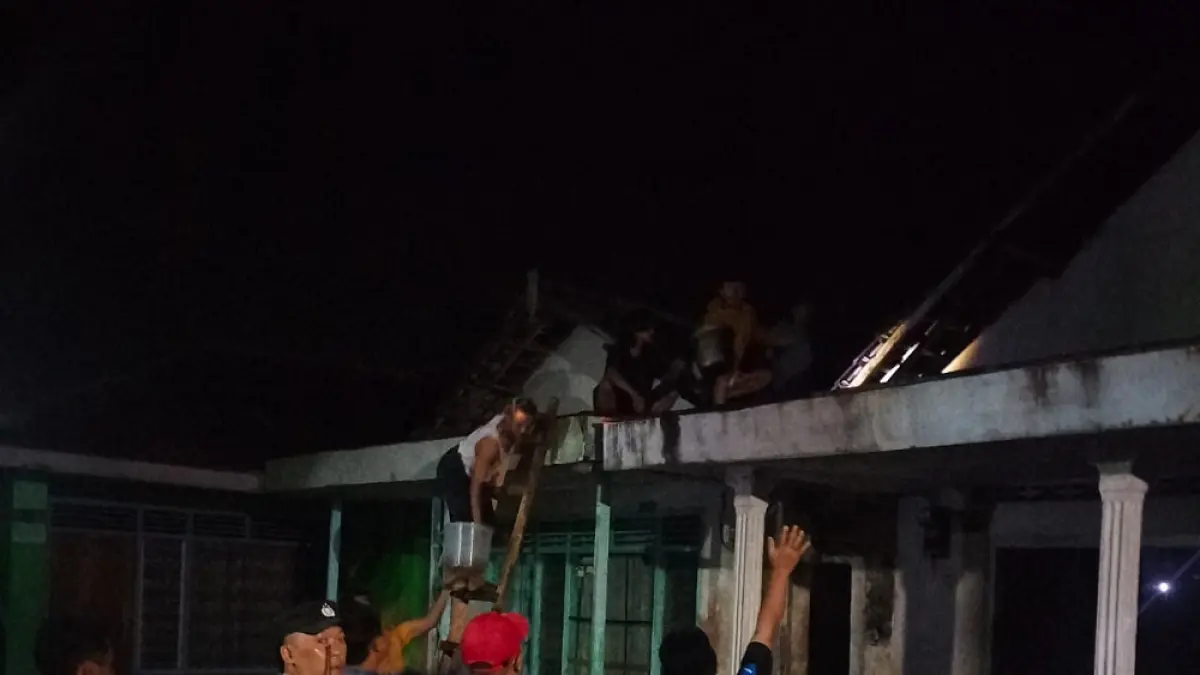 Sebelum damkar tiba di lokasi, warga dibantu aparat melakukan pemadaman manual