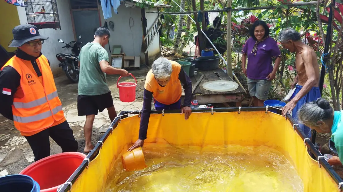 ANDALKAN BANTUAN: Warga di desa yang terdampak kekeringan mengambil air bersih di tandon yang disediakan BPBD kemarin.